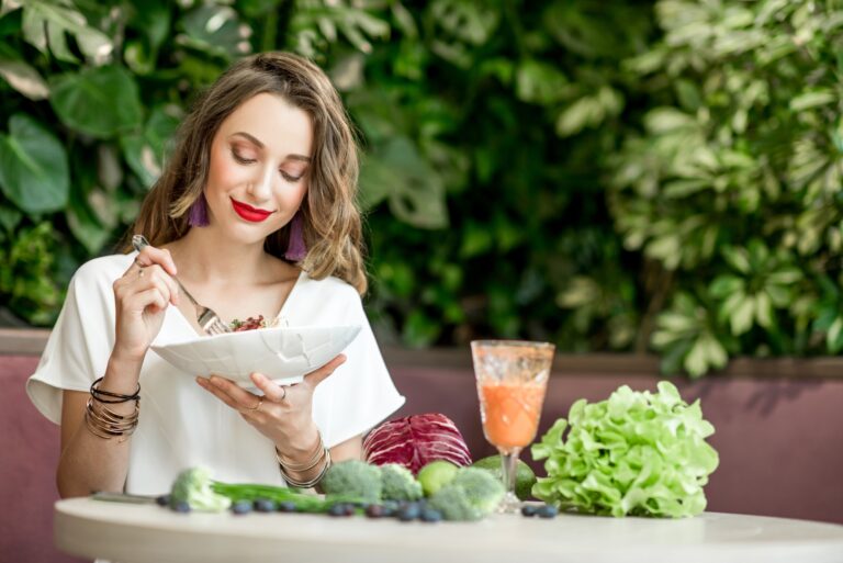 Woman with healthy food on the green wall background